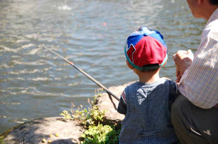 釣り堀で子供に教える父親