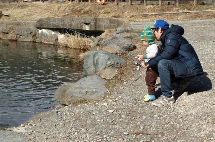 子供に釣りを教えるお父さん