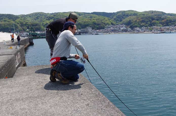 座って釣りをする画像