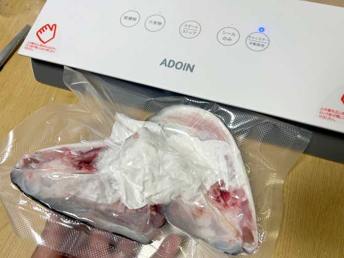 魚のアラを真空パックする様子