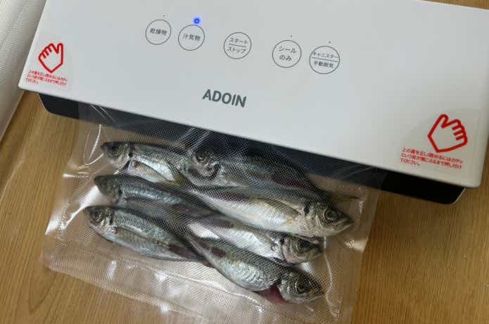真空パック機でアジを真空する様子